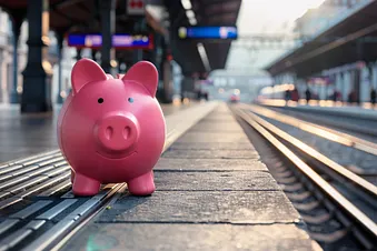 Rosarotes Sparschwein an einem Bahnhof in der Schweiz. (KI-Bild))