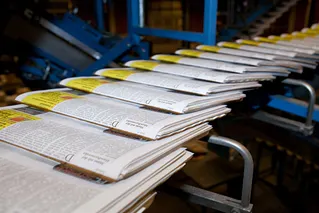 Zeitungen auf Fliessband am Ende einer Druckerpresse