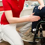 Therapeutin behandelt Patientin im Rollstuhl