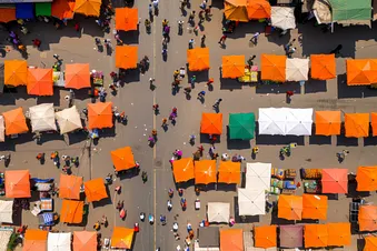 Sicht von oben auf einen Markt in Indien mit bunten Sonnenschirmen.