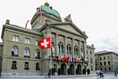 Bundeshaus in Bern, Schweiz, mit Landesfahne und Kantonsfahnen.